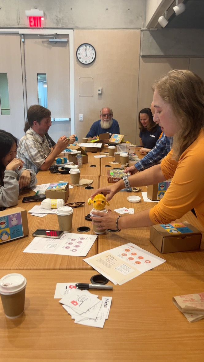 A photo of a group of caregivers sitting around a table covered in crafting materials and coffee cups. 